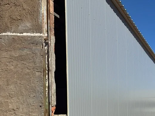 Auvent métallique et extension adossée à un bâtiment existant